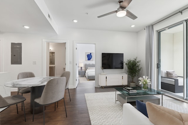 living room featuring dark hardwood / wood-style flooring, electric panel, and ceiling fan