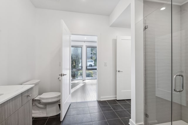 bathroom featuring tile patterned flooring, vanity, an enclosed shower, and toilet