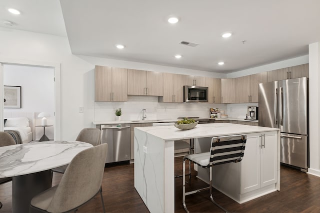 kitchen with a center island, dark hardwood / wood-style flooring, sink, and appliances with stainless steel finishes