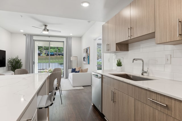 kitchen featuring dark hardwood / wood-style floors, ceiling fan, light stone counters, and sink