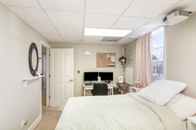 carpeted bedroom with a drop ceiling