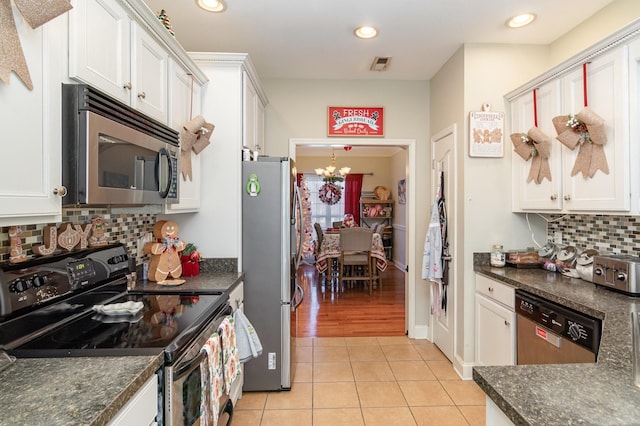 kitchen featuring white cabinetry, light tile patterned floors, stainless steel appliances, and an inviting chandelier