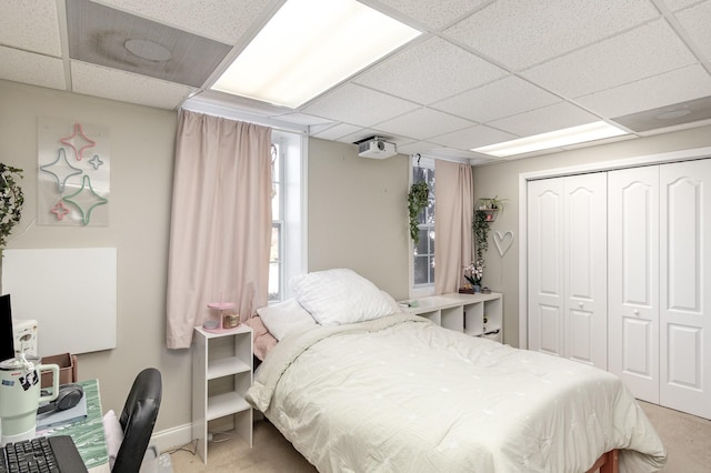 bedroom featuring a drop ceiling and a closet