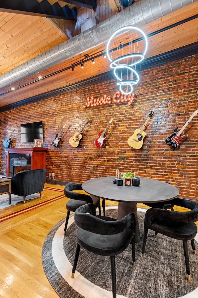 dining room featuring brick wall and hardwood / wood-style flooring