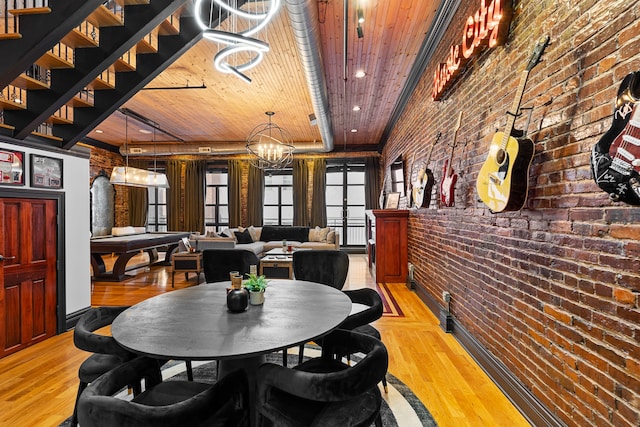 dining room featuring wooden ceiling, light hardwood / wood-style floors, and brick wall