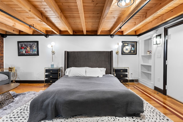 bedroom with beamed ceiling, light hardwood / wood-style floors, and wood ceiling