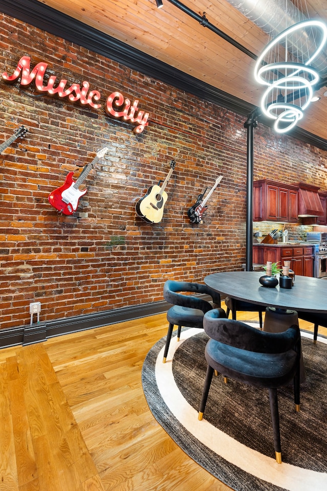 dining area featuring light hardwood / wood-style flooring and brick wall