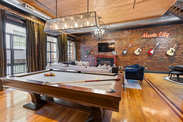 recreation room with wood ceiling, light hardwood / wood-style flooring, brick wall, and pool table