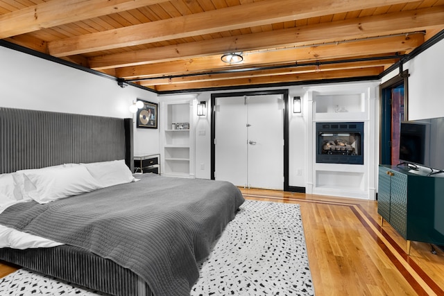 bedroom featuring beam ceiling, wood ceiling, and light hardwood / wood-style flooring