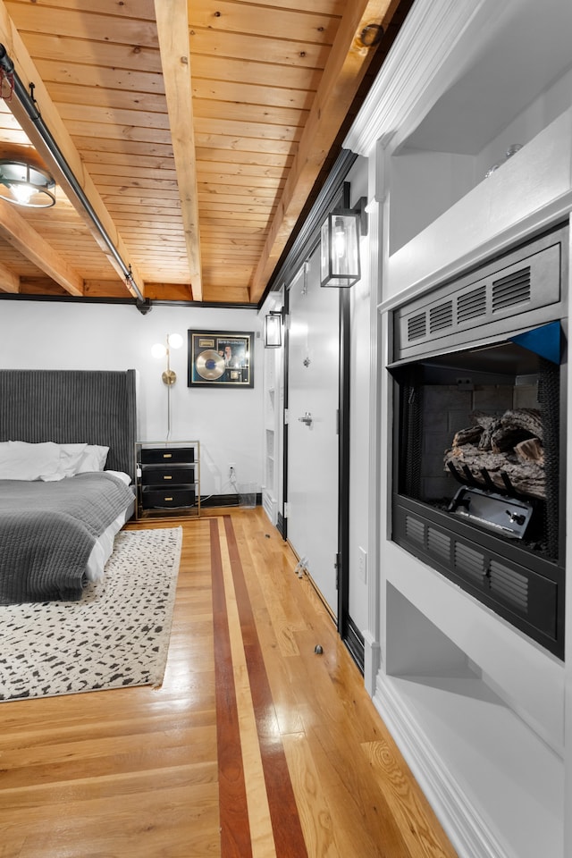 bedroom featuring beamed ceiling, wooden ceiling, and hardwood / wood-style flooring