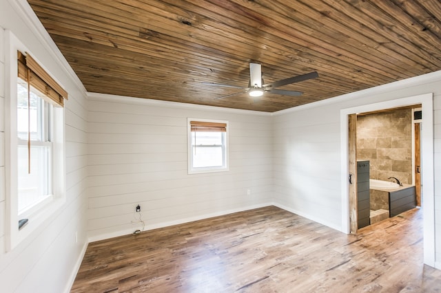 empty room with wooden walls, ceiling fan, wood ceiling, and hardwood / wood-style flooring