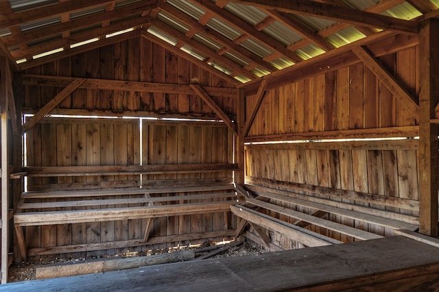 misc room featuring wooden walls and lofted ceiling