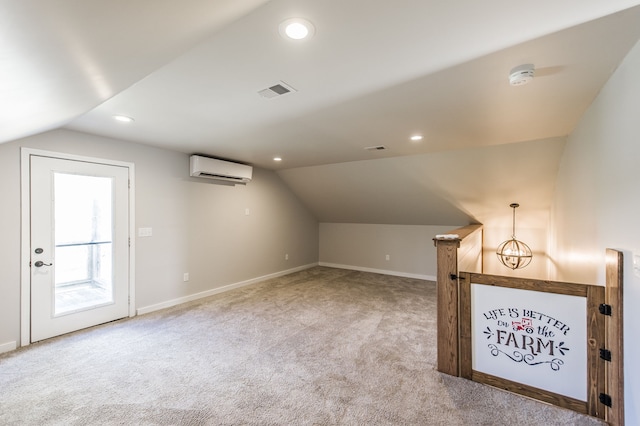 bonus room featuring a wall unit AC, light carpet, and vaulted ceiling