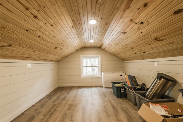 additional living space with hardwood / wood-style floors, lofted ceiling, wooden ceiling, and wood walls