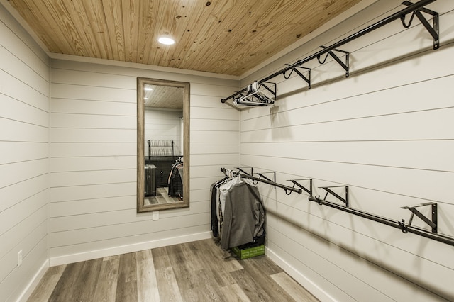 laundry area featuring wood-type flooring, wooden walls, and wood ceiling