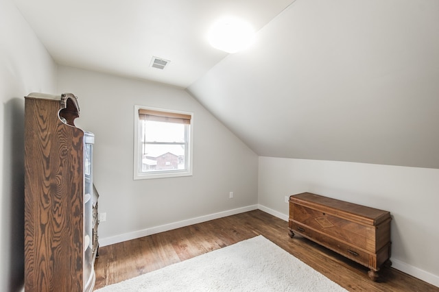 bonus room with lofted ceiling and dark hardwood / wood-style floors