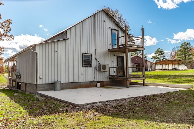 back of property featuring a lawn, ac unit, a balcony, and a patio