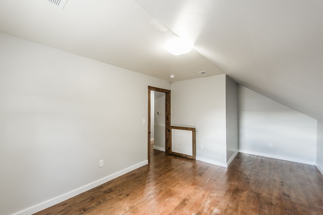 additional living space featuring vaulted ceiling and hardwood / wood-style flooring