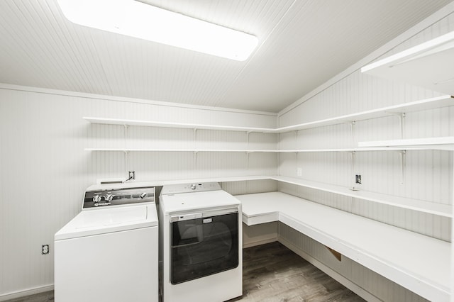 laundry area with hardwood / wood-style floors, separate washer and dryer, and wood walls