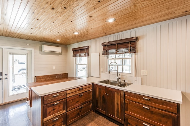 kitchen with dark wood-type flooring, sink, wooden walls, a wall mounted AC, and kitchen peninsula