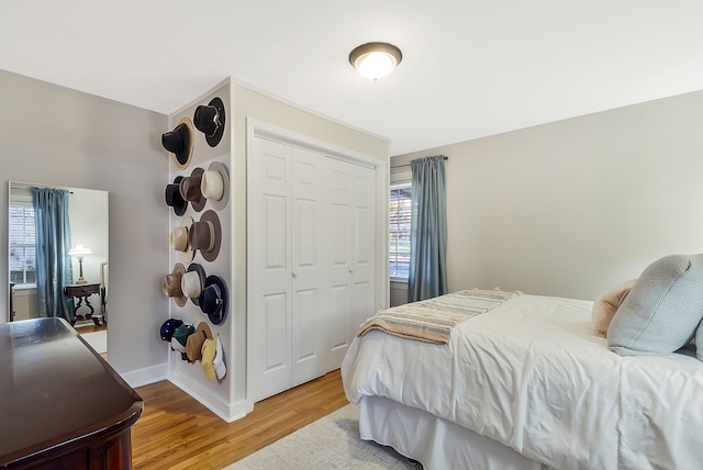 bedroom featuring hardwood / wood-style flooring, a closet, and multiple windows