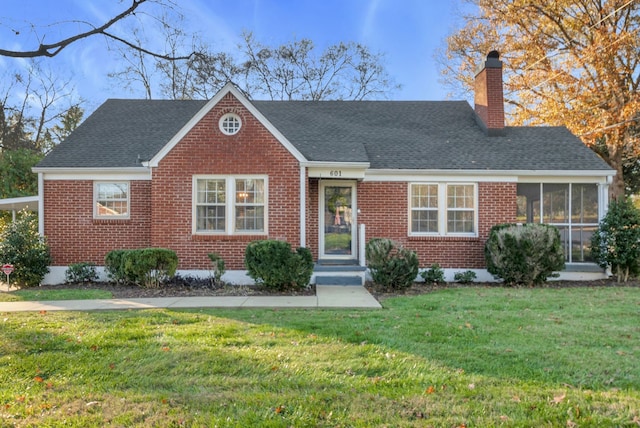 view of front of home with a sunroom and a front yard