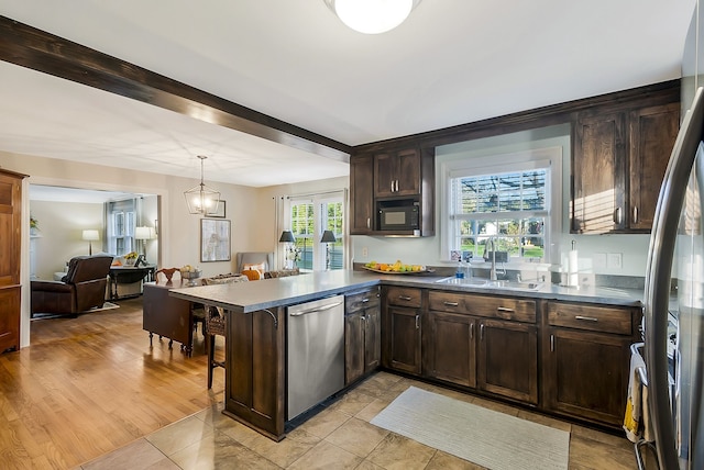 kitchen with kitchen peninsula, light wood-type flooring, stainless steel dishwasher, dark brown cabinetry, and sink