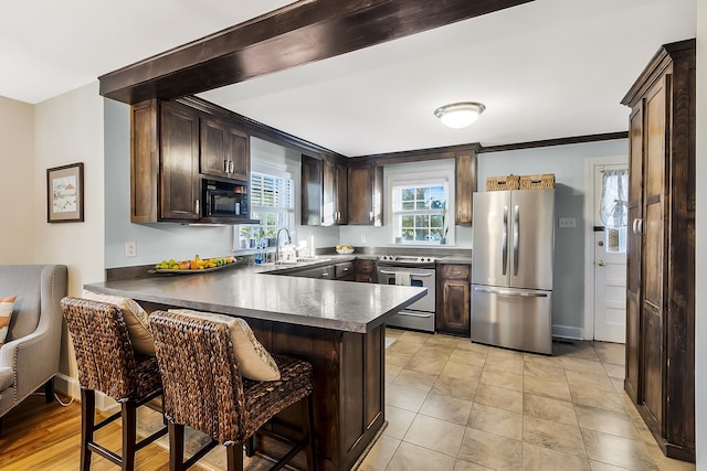 kitchen with kitchen peninsula, a breakfast bar, stainless steel appliances, crown molding, and sink