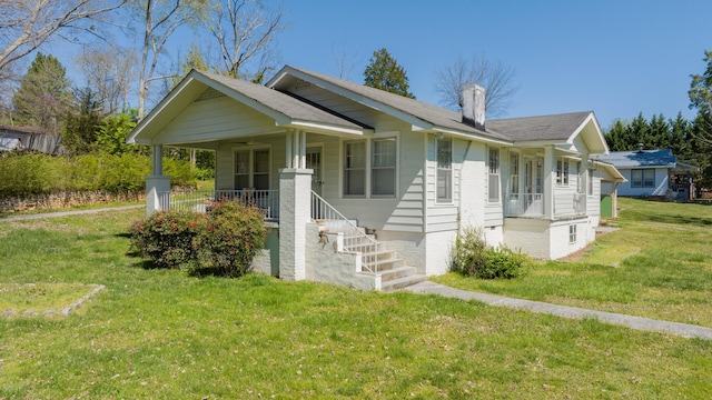 view of front of property with covered porch and a front yard