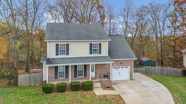 view of property featuring a garage, covered porch, and a front yard