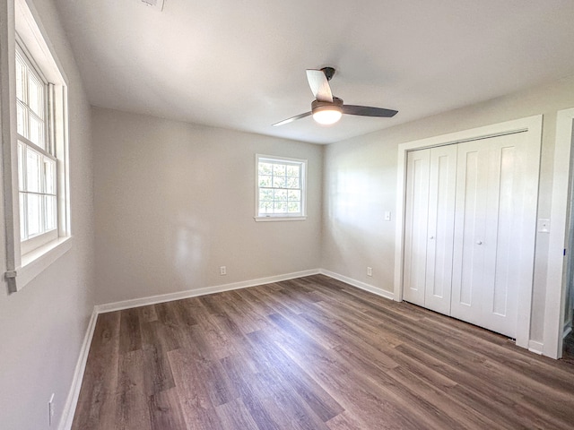 unfurnished bedroom with ceiling fan, dark hardwood / wood-style flooring, and a closet