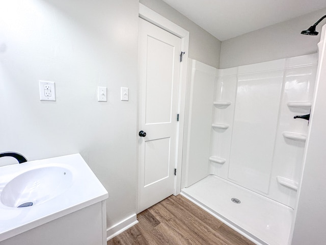 bathroom featuring vanity, wood-type flooring, and walk in shower