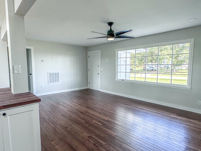 unfurnished living room featuring dark hardwood / wood-style floors and ceiling fan