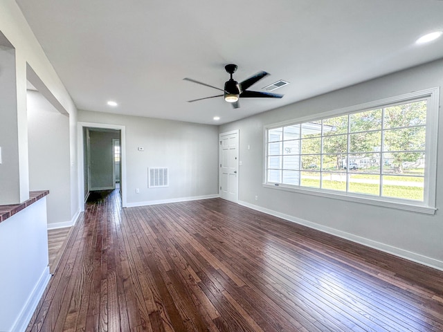 unfurnished living room with ceiling fan and dark wood-type flooring