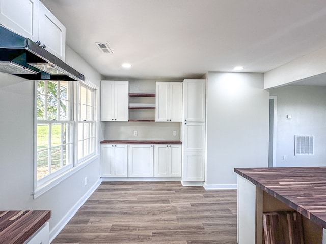 kitchen with white cabinets, light hardwood / wood-style floors, and butcher block counters