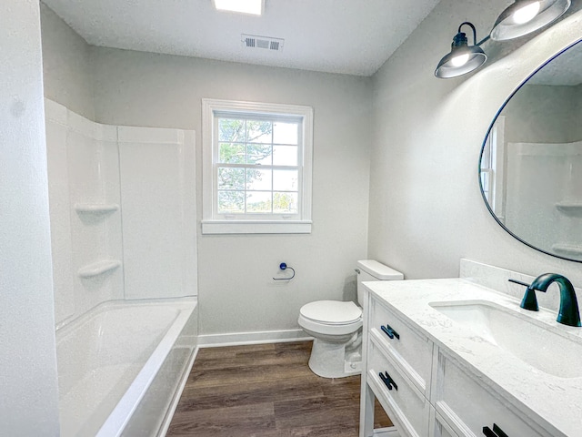 full bathroom featuring shower / washtub combination, hardwood / wood-style floors, vanity, and toilet