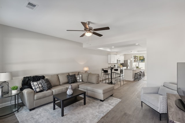 living room featuring ceiling fan and light hardwood / wood-style floors