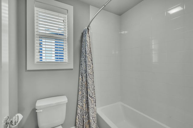 bathroom featuring plenty of natural light, shower / bath combination with curtain, and toilet