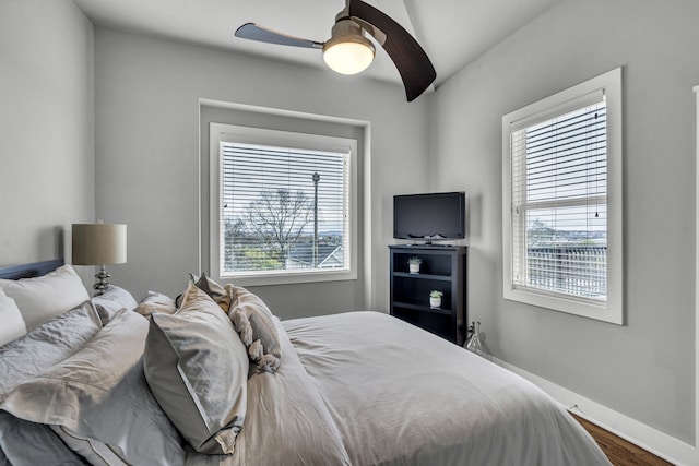 bedroom featuring multiple windows, ceiling fan, vaulted ceiling, and hardwood / wood-style flooring