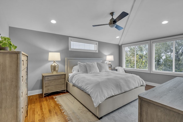 bedroom featuring light hardwood / wood-style flooring, vaulted ceiling, and ceiling fan