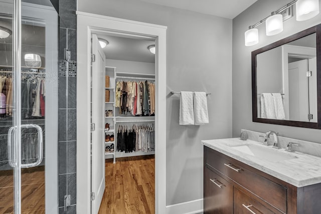 bathroom featuring hardwood / wood-style floors, vanity, and a shower with door