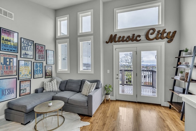 living room featuring light hardwood / wood-style floors and a high ceiling