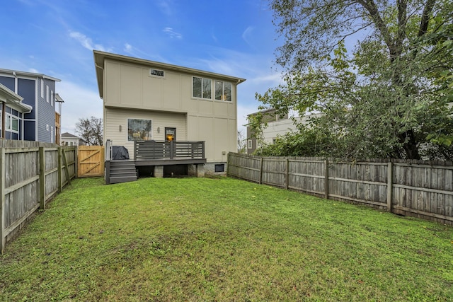 back of property with a yard and a deck