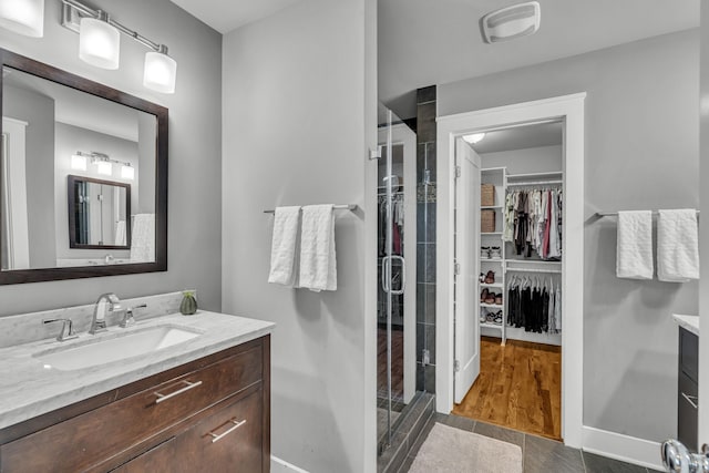 bathroom featuring vanity, an enclosed shower, and wood-type flooring