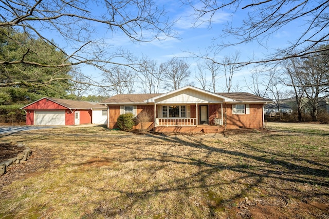 single story home featuring an outbuilding, a porch, a garage, and a front yard