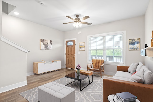 living room featuring light hardwood / wood-style flooring and ceiling fan