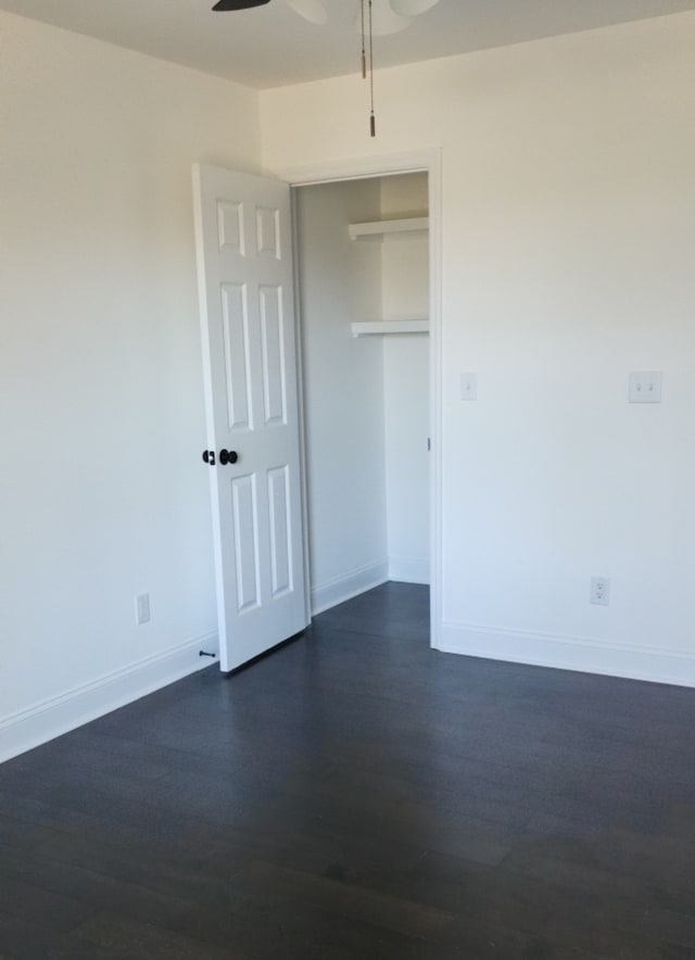 unfurnished bedroom featuring ceiling fan and dark hardwood / wood-style flooring