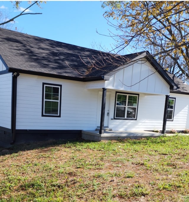 back of house featuring covered porch and a yard