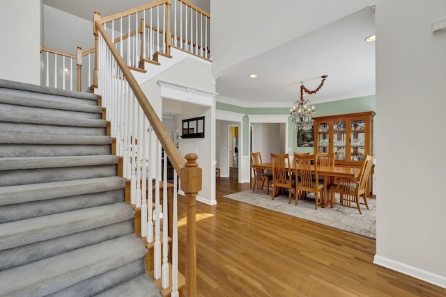 stairway featuring hardwood / wood-style floors and an inviting chandelier