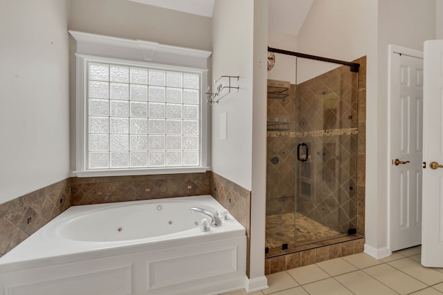 bathroom featuring tile patterned floors, a healthy amount of sunlight, separate shower and tub, and vaulted ceiling